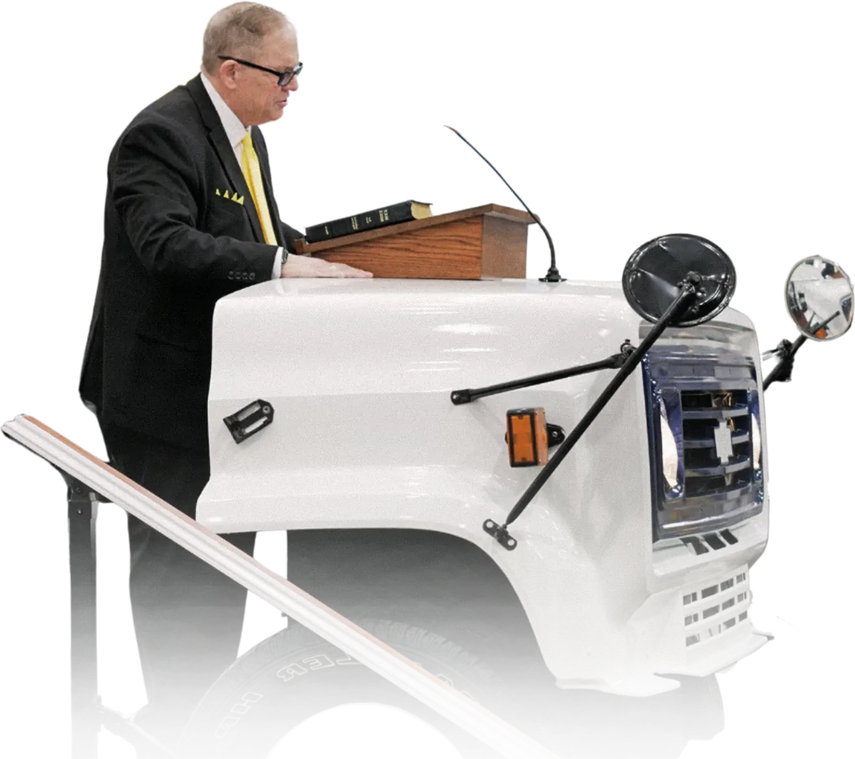 Pastor Bill Reeves preaching from the pulpit built into the front of a white bus